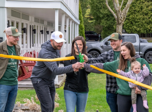Group cutting ribbon at outdoor ceremony