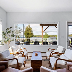 Modern living room with large window and chairs.