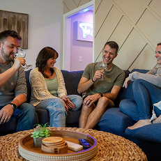 Group enjoying drinks and relaxing on a couch.