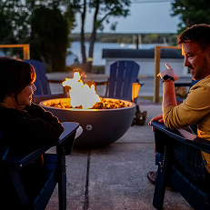 People talking by a cozy fire pit outdoors.