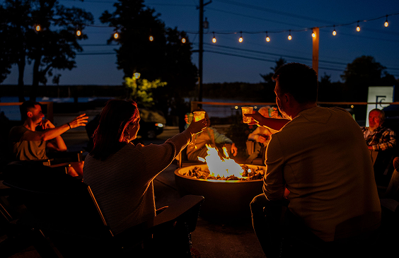 People toasting around a campfire at night