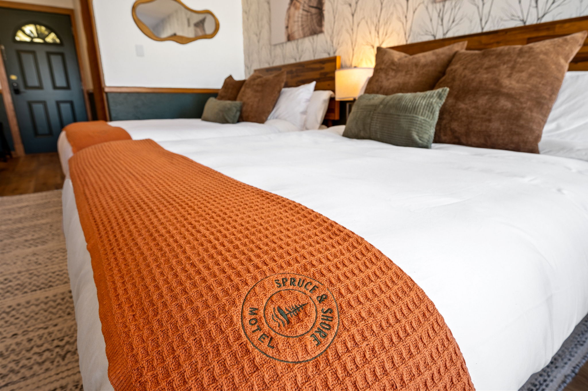 Cozy motel bed with orange blanket.
